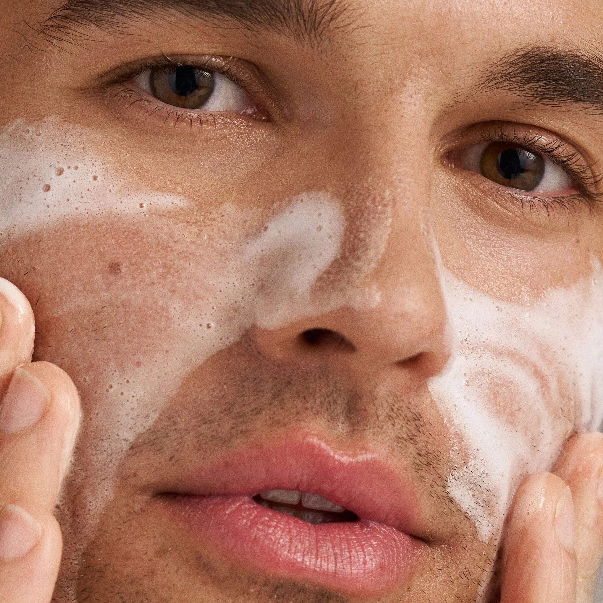Dermalogica Clearing Skin Wash 500ml, man die reinigingsschuim op zijn gezicht aanbrengt voor een frisse huid.