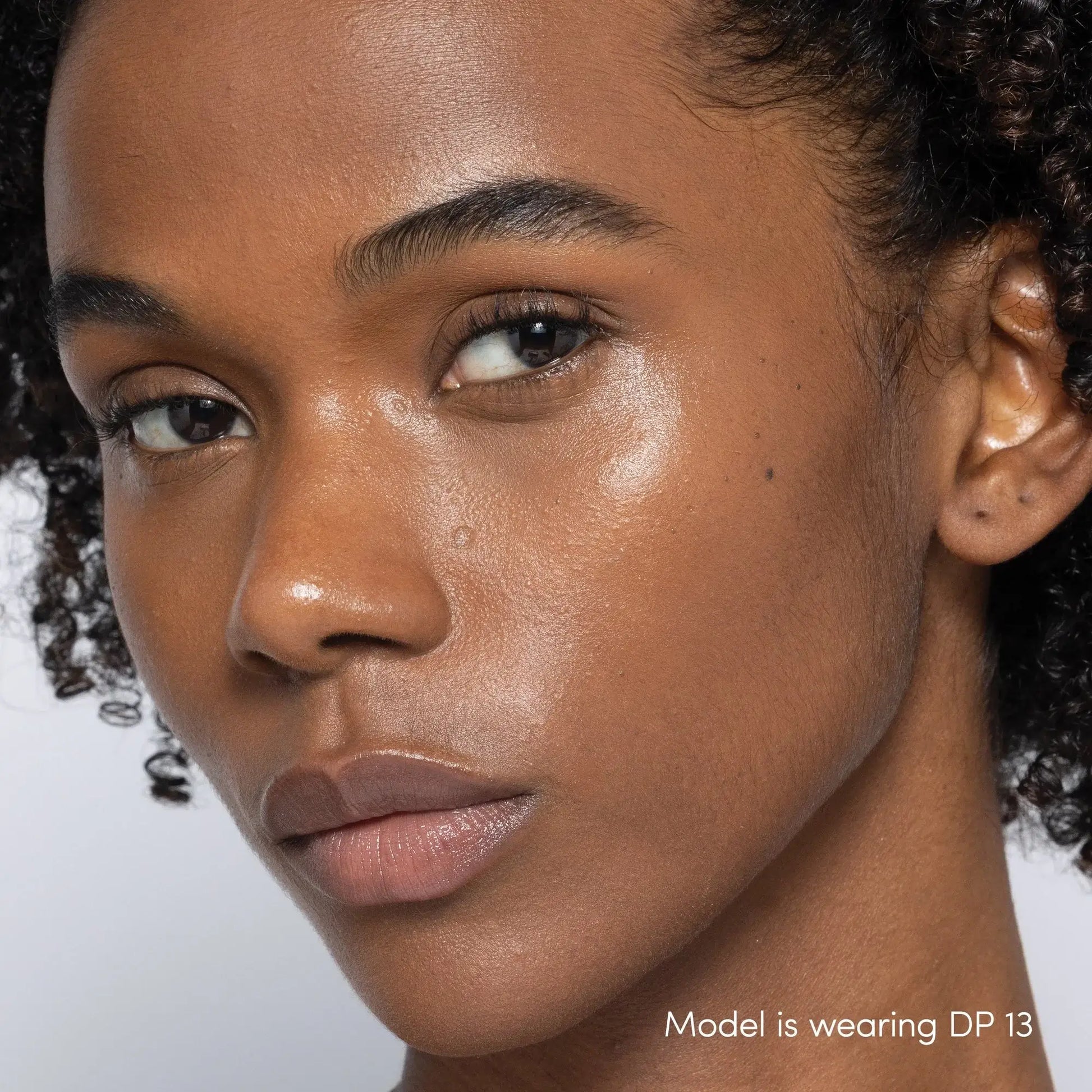 Jane Iredale Skintuition Brightening Under Eye Concealer DP13 op model met diepe huidtint en gouden ondertoon, natuurlijk effect.