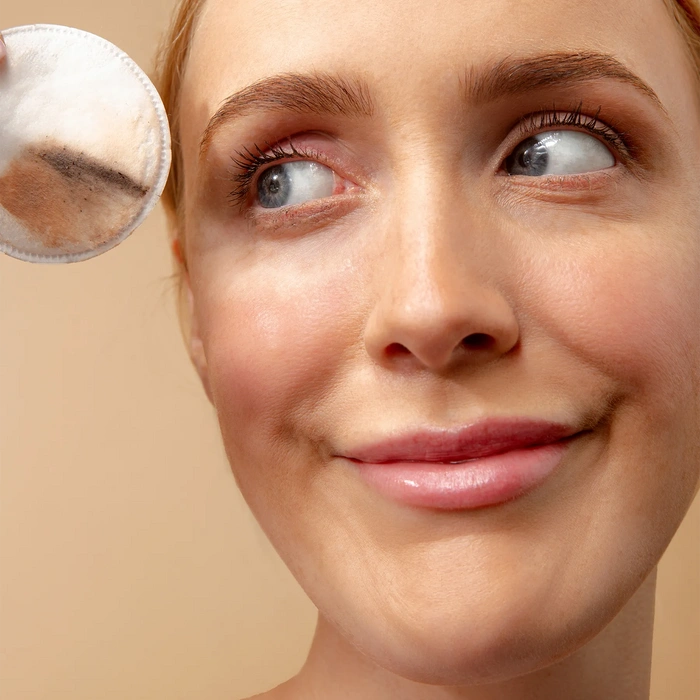LYCON Skin Eye Makeup Remover 125ml, vrouw die oogmake-up verwijdert met watje, zachte en effectieve reiniging.