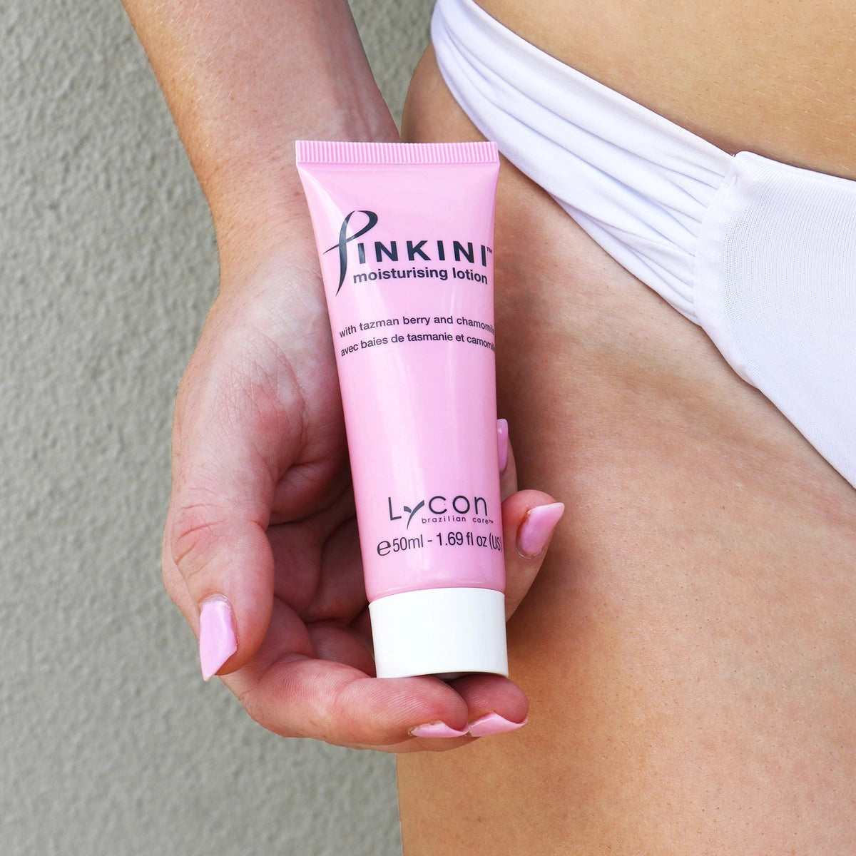 Lycon Pinkini Moisturising Lotion 50ml in hand, essential for soothing bikini area post-waxing, pink tube design.