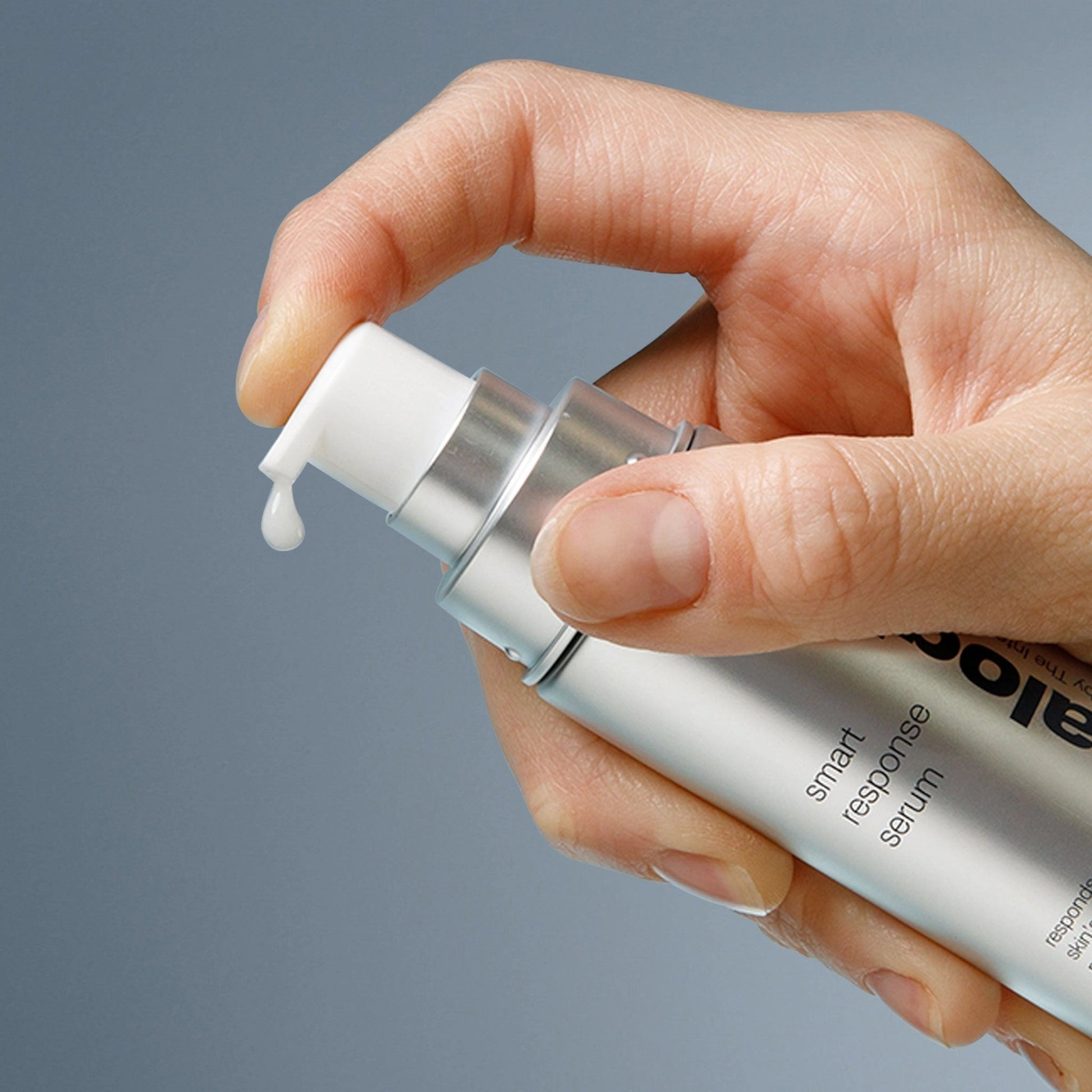 Dermalogica Smart Response Serum 59ml in gebruik met een hand die het pompje van de verpakking indrukt.